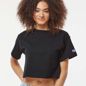 Woman with curly poofy hair wearing a black Champion crop top.