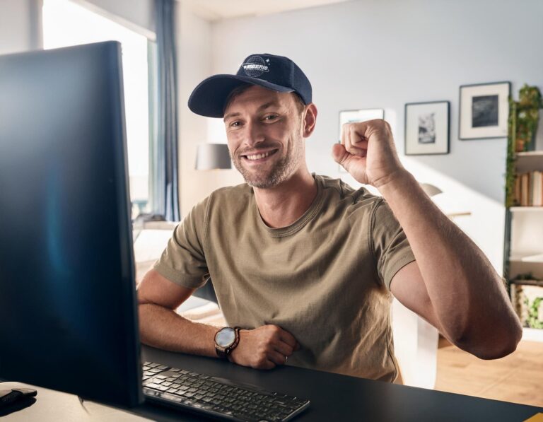 Man happy in front of computer because of Etsy sales using Hollywood Prints POD