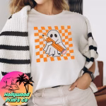 A woman wearing a shirt with the image of a ghost holding a pencil