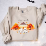 A cream sweater of Gillmore ghouls in front of a gazebo with fall leaves surrounding them.