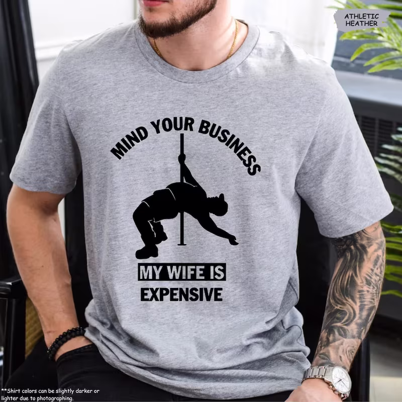 Man wearing a Funny Husband Shirt in gray color variant that says Mind Your Business My Wife Is Expensive.
