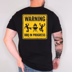Man wearing a Warning BBQ In Progress Shirt featuring a funny BBQ grilling design, perfect Father’s Day grill master gift for men.